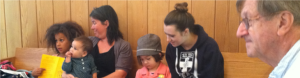 Kids & adults on a bench in Berkeley Friends Church's worship room